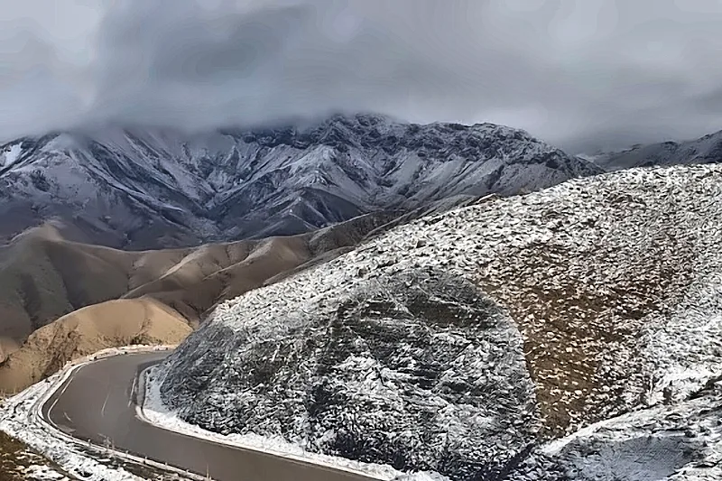 I tornanti innevati della strada di montagna sotto le nuvole
