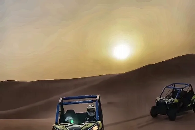 Un buggy sulle dune con il sole che tramonta dietro