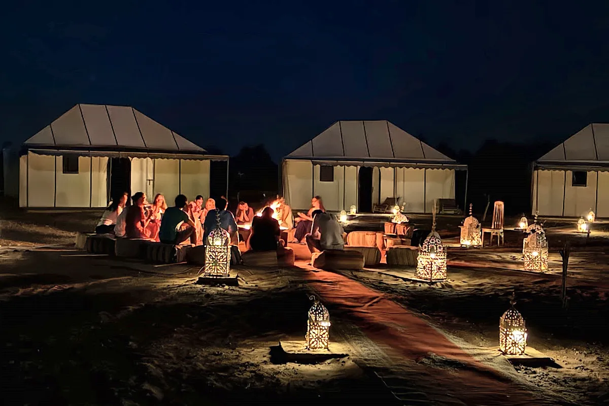 Tende illuminate di notte con i bracieri accesi davanti