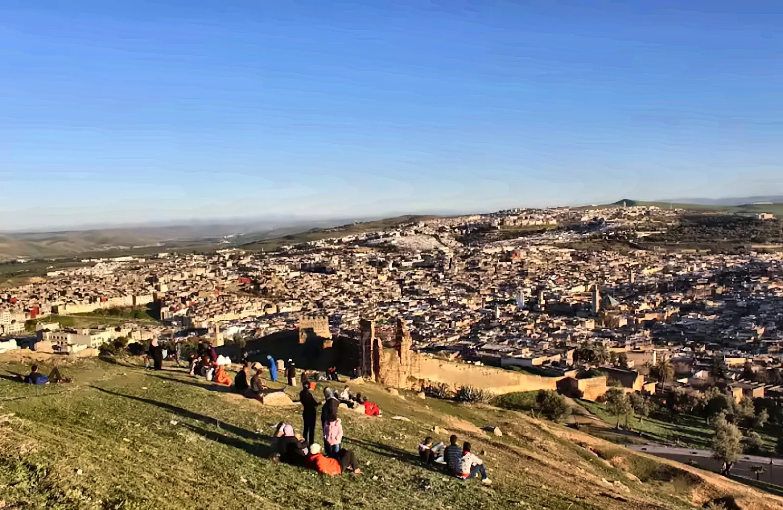 La medina di Fes vista dalla collina, con la gente seduta sul prato