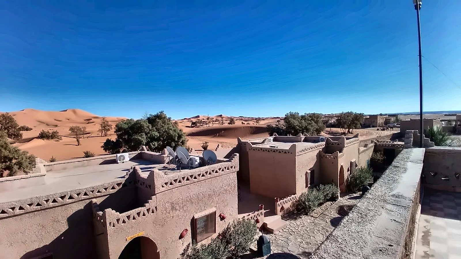 I tetti in terra cruda della kasbah con le dune dell’Erg Chebbi alle spalle