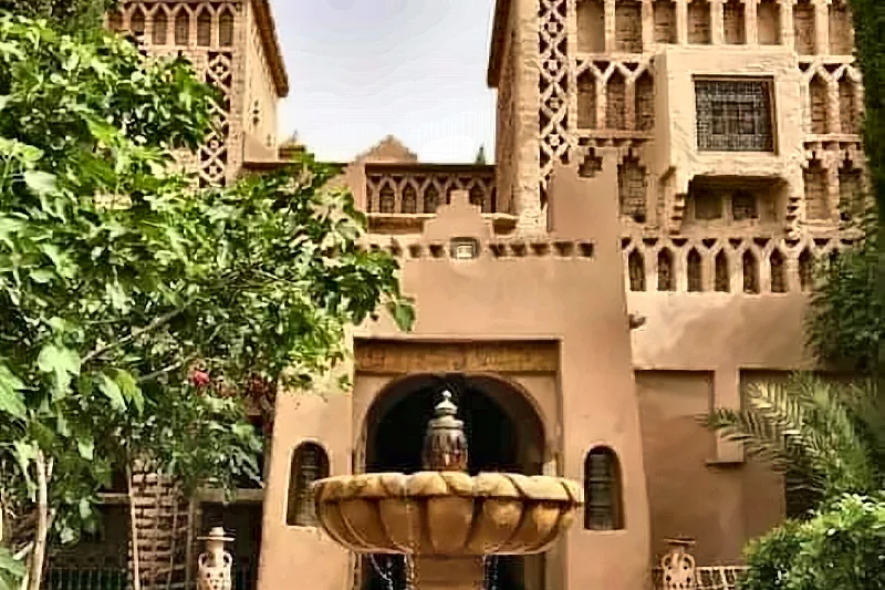 Il cortile di una kasbah con la fontana scolpita davanti alla facciata decorata