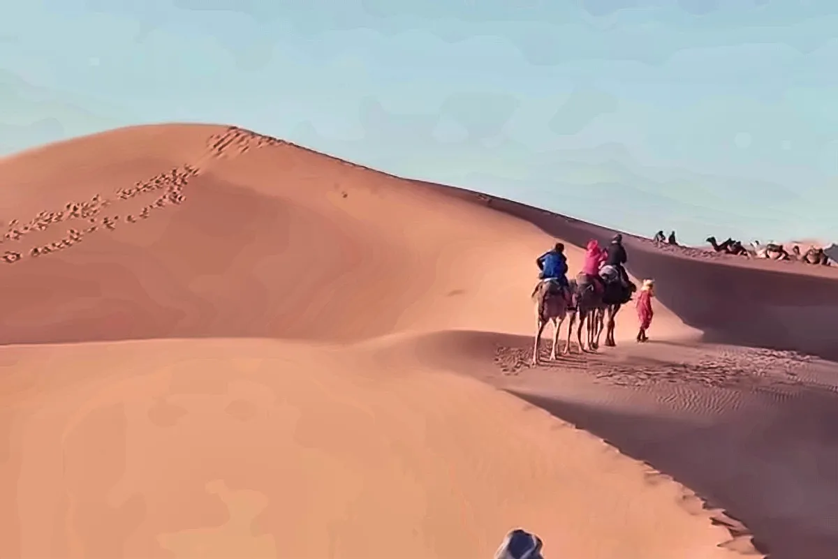 Una persona in piedi sul crinale di una duna nel deserto