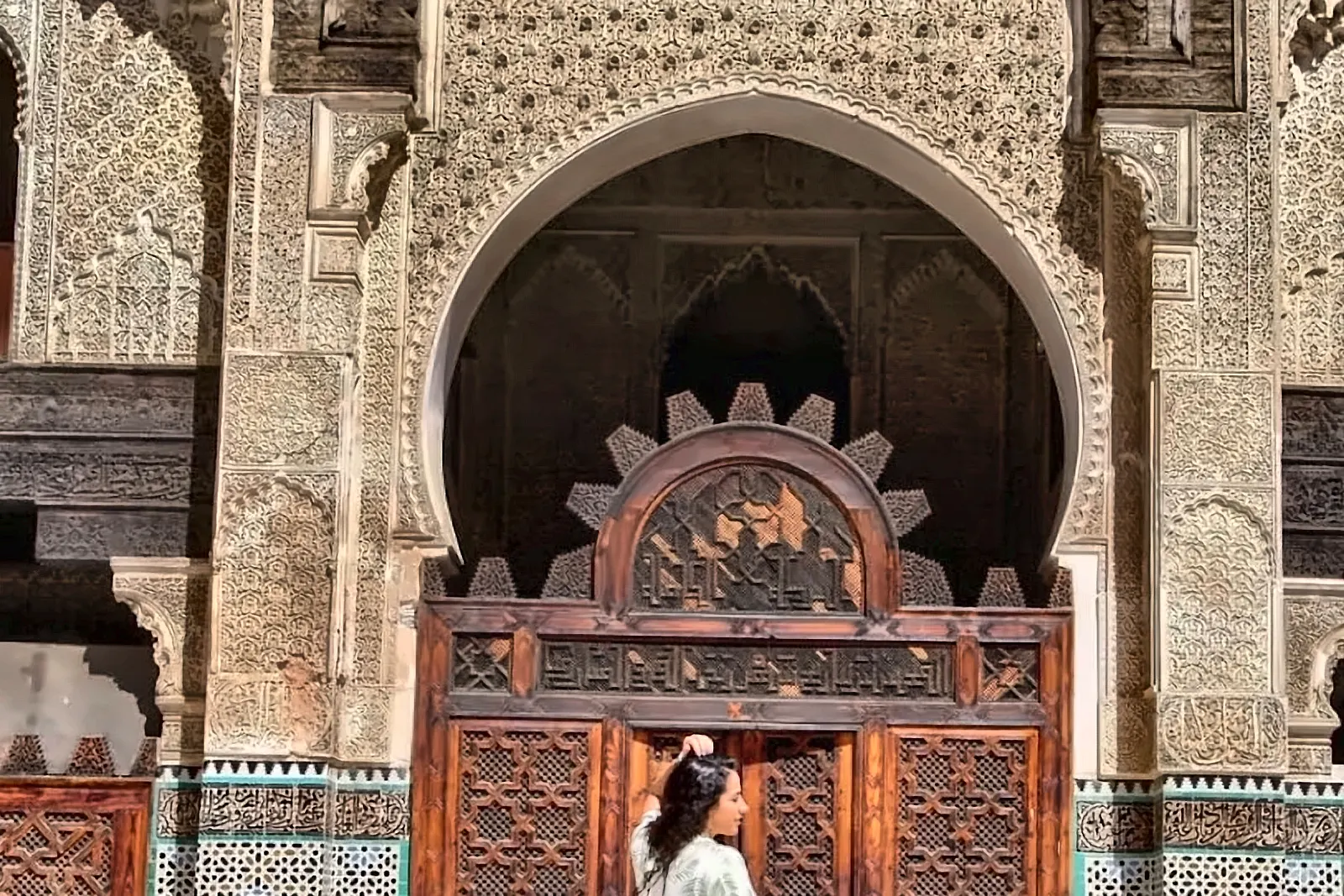 Portale monumentale decorato con una visitatrice davanti