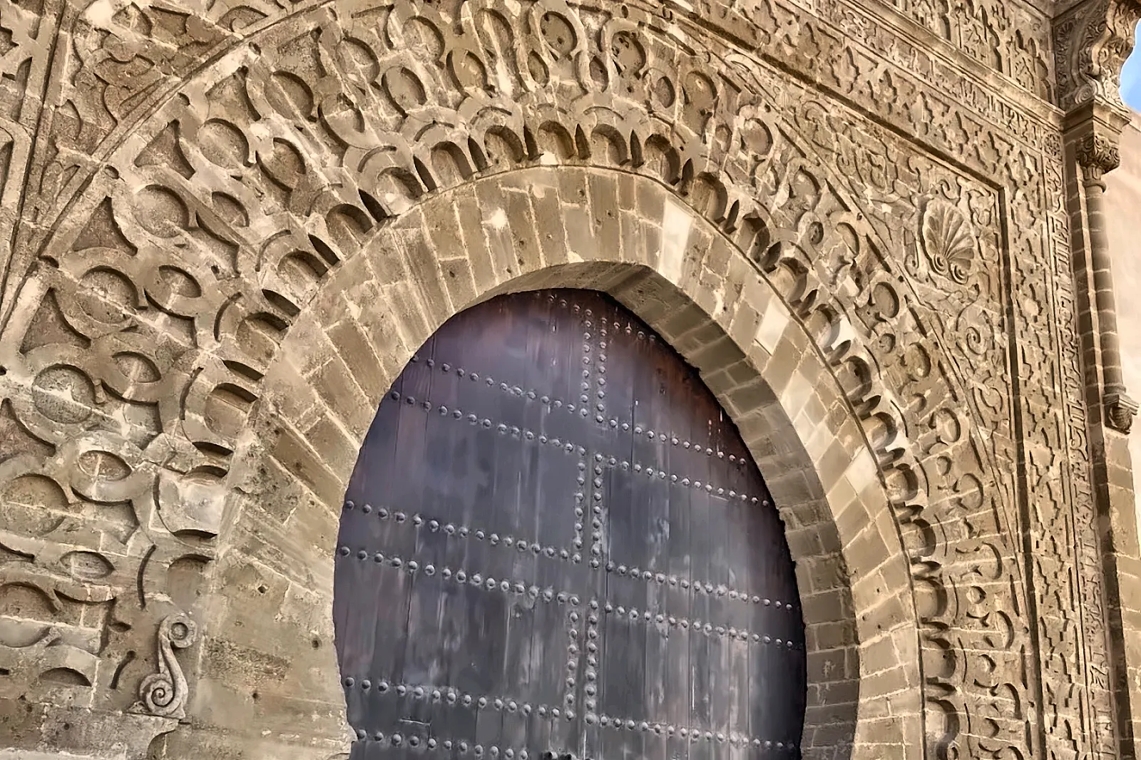 Gruppo di visitatori davanti a una grande porta storica
