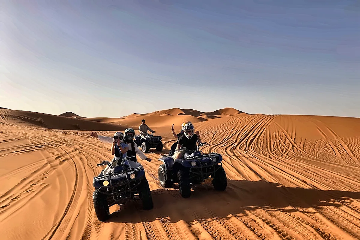 Un gruppo di quad fermi sulla sabbia fra le dune