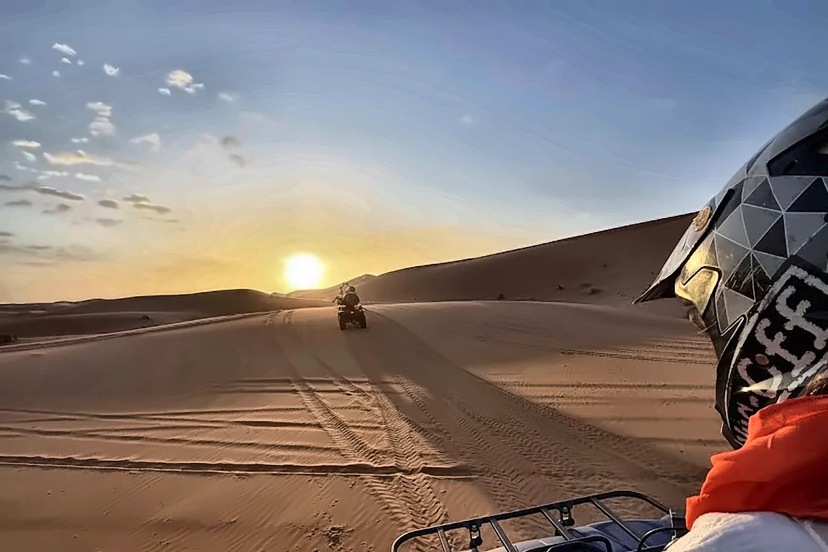 Vista dal manubrio di un quad con il sole basso sulle dune