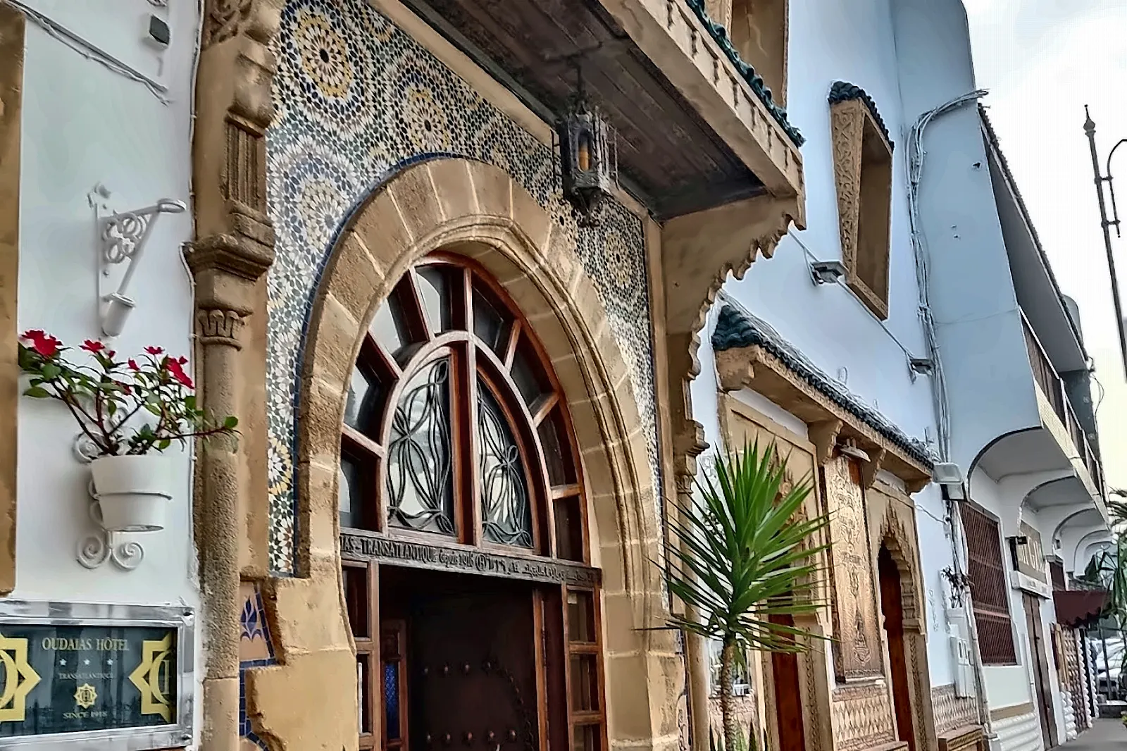 Il portale scolpito di una casa bianca nei vicoli di Rabat, con le piante davanti