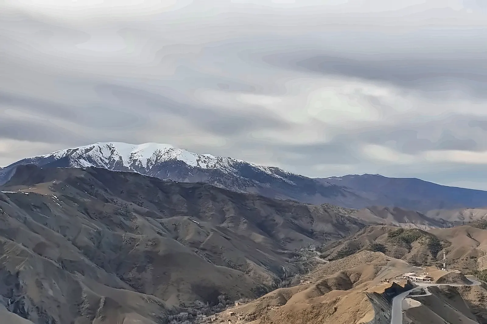 I tornanti della strada di montagna con la neve sulle vette