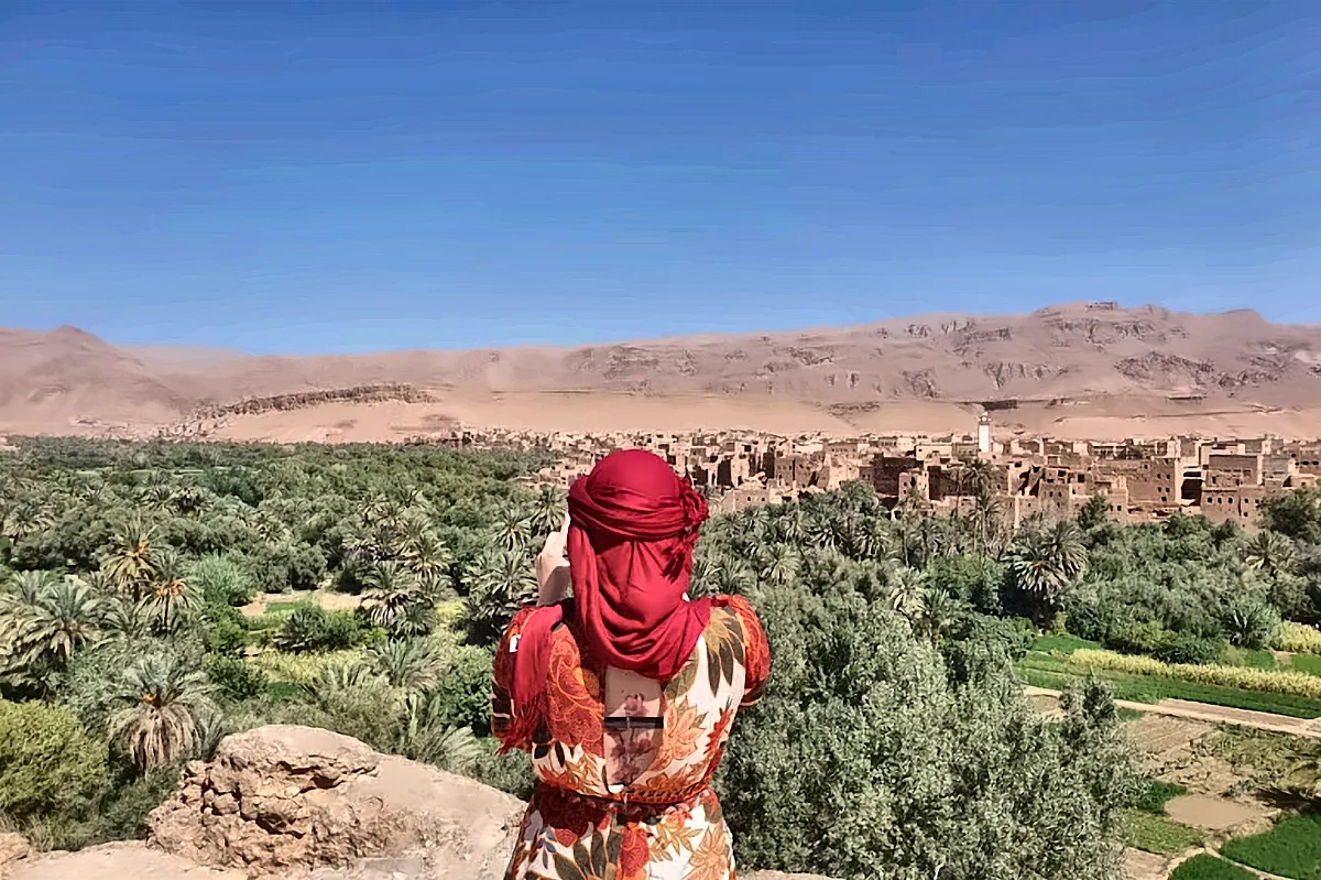 Una viaggiatrice con il foulard rosso guarda la valle del Dades